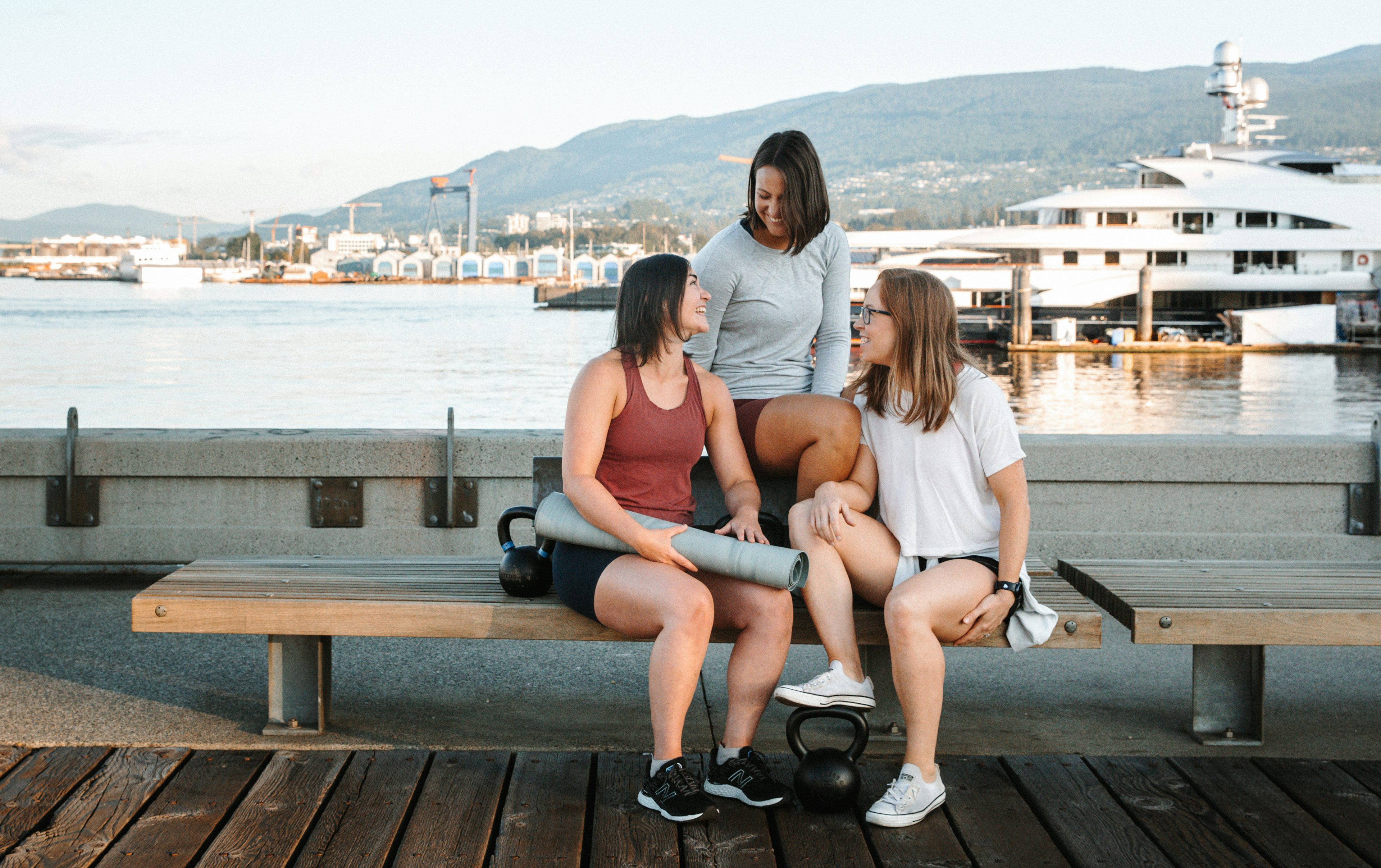 Briana, Jess, and Andrea sitting on a pier
