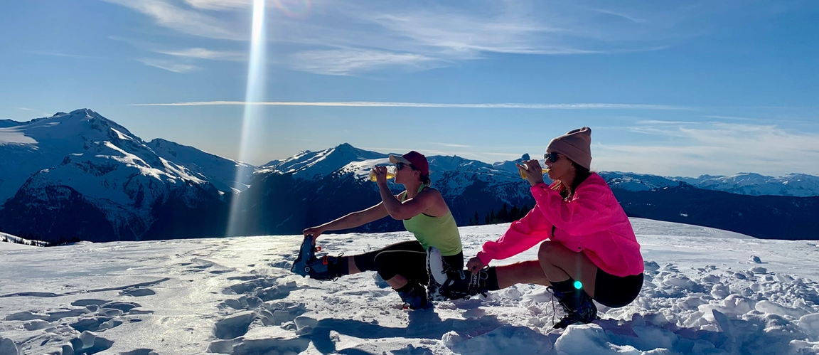 Briana and Karli doing pistol squats on a mountain.